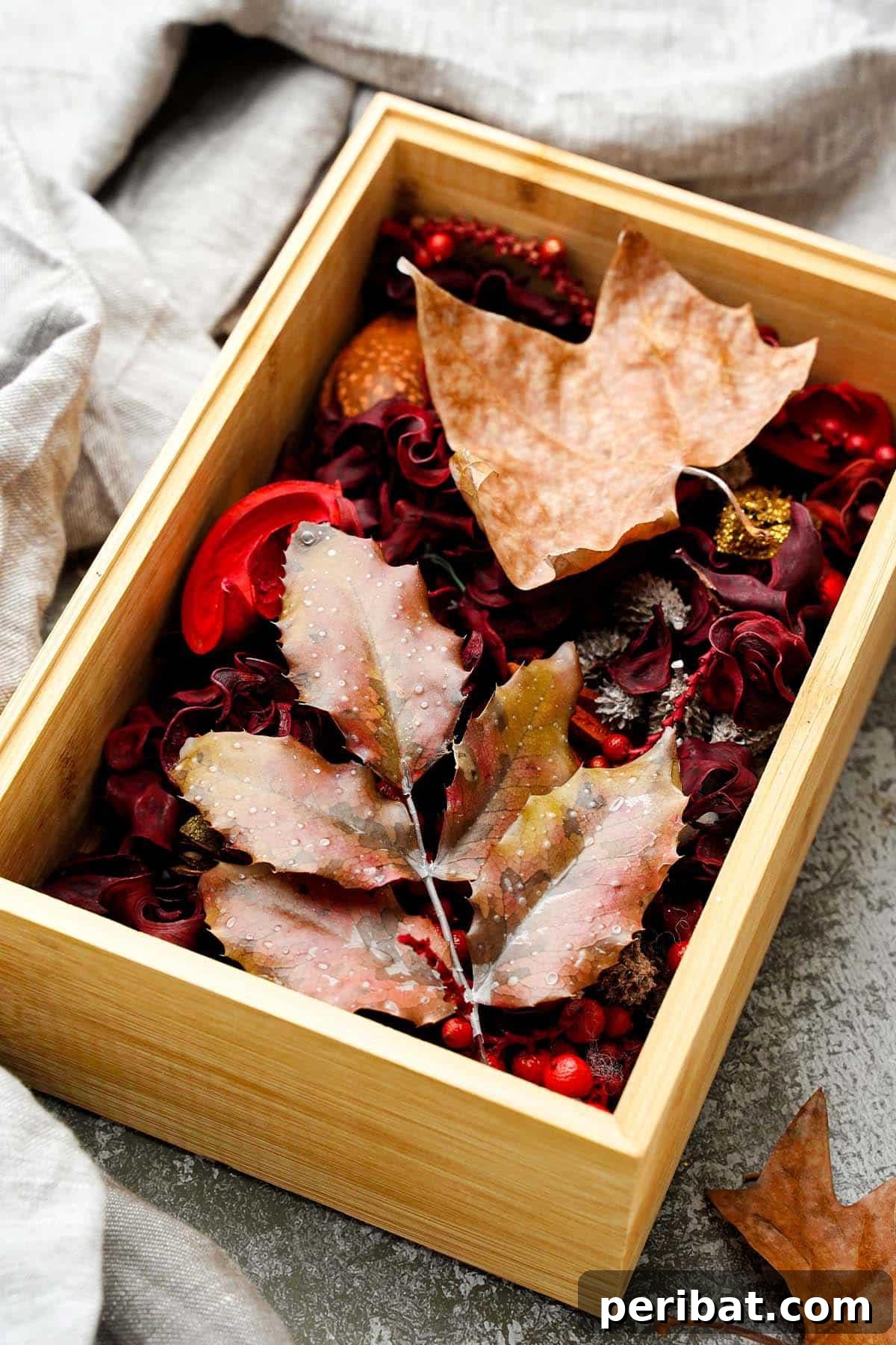 A collection of perfectly preserved fall leaves displayed in a decorative box, showcasing their vibrant autumn colors for lasting enjoyment.