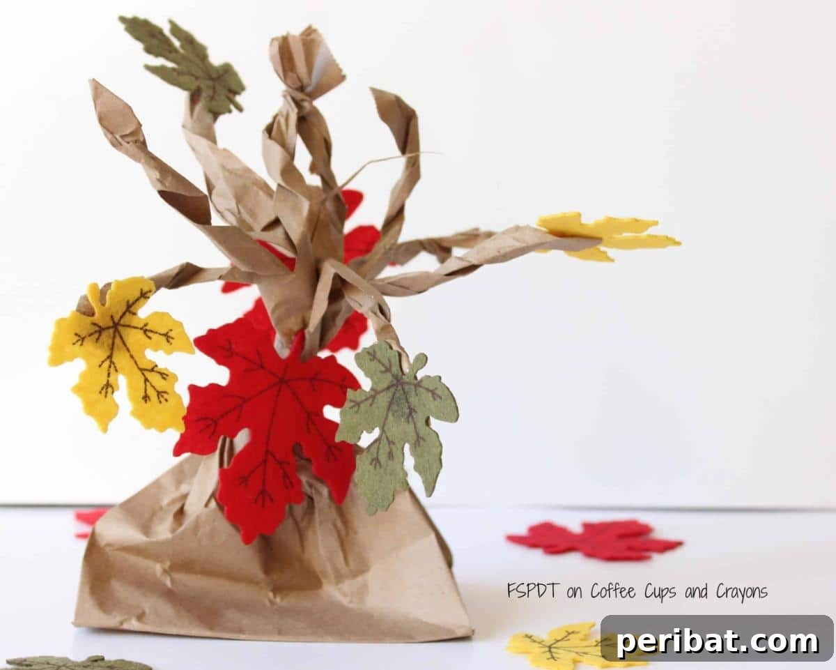 A charming DIY fall paper bag tree adorned with colorful felt leaves, a simple and whimsical craft perfect for engaging kids and adding a festive touch to any room.