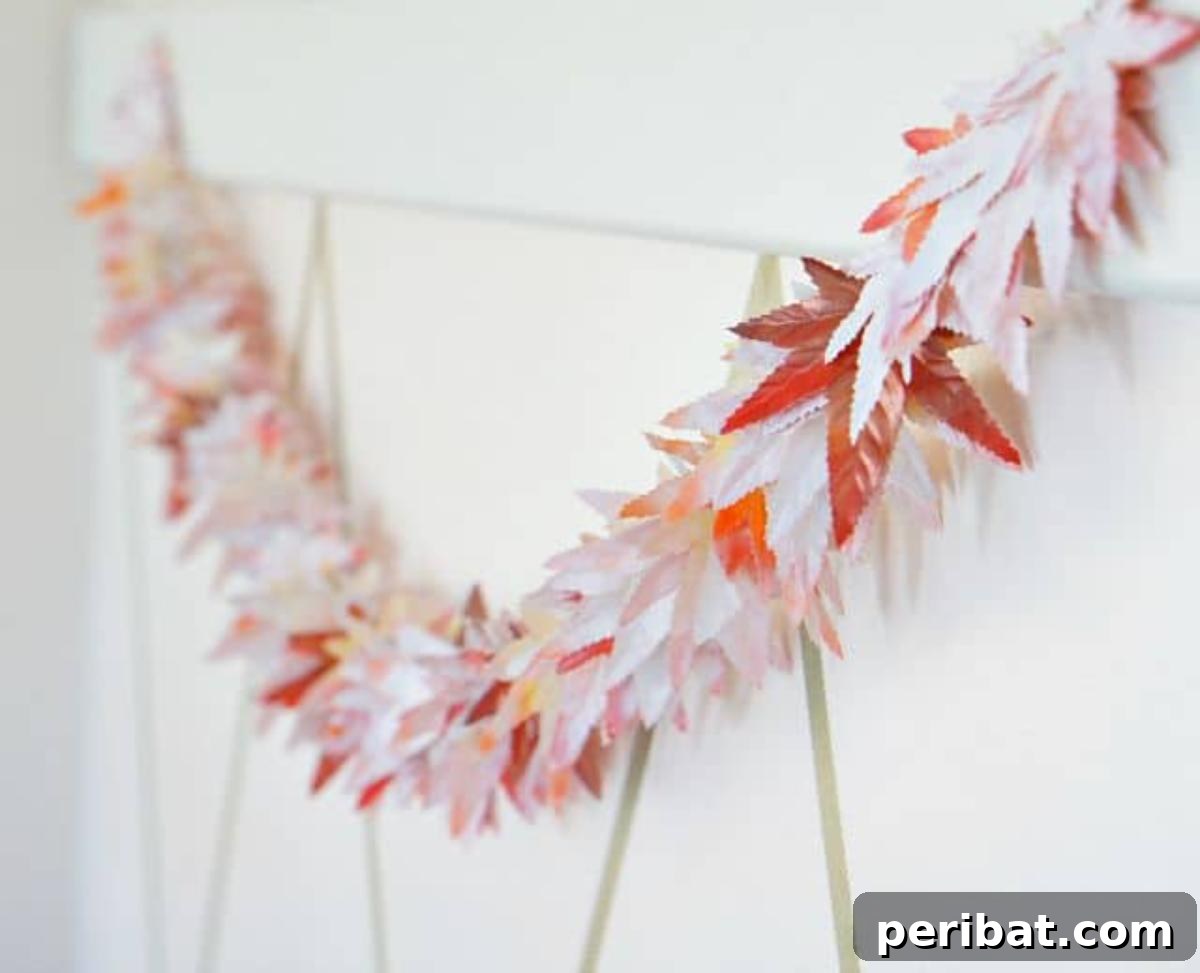 An ingenious Dollar Store fall garland DIY, featuring silk leaves transformed with spray paint into custom autumn colors, creating an inexpensive yet vibrant seasonal decoration.