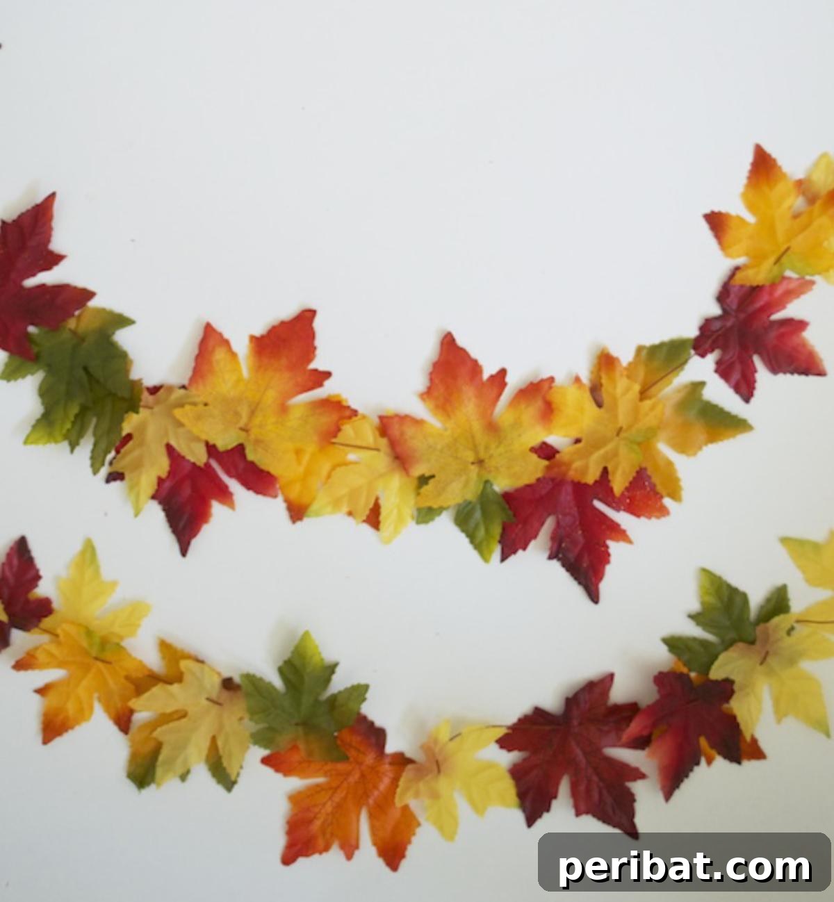 A classic and charming DIY fall leaf garland, featuring colorful autumn leaves strung together to create a festive decoration for mantels, doorways, or banisters.