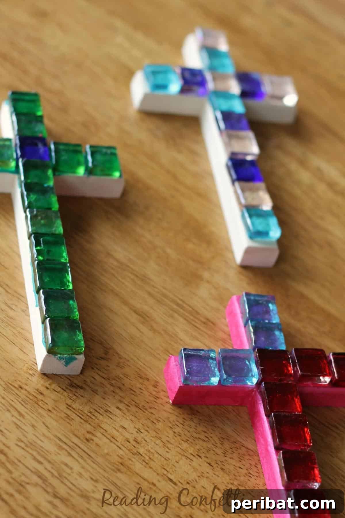 An easy mosaic cross craft made with colorful tiles on a base.