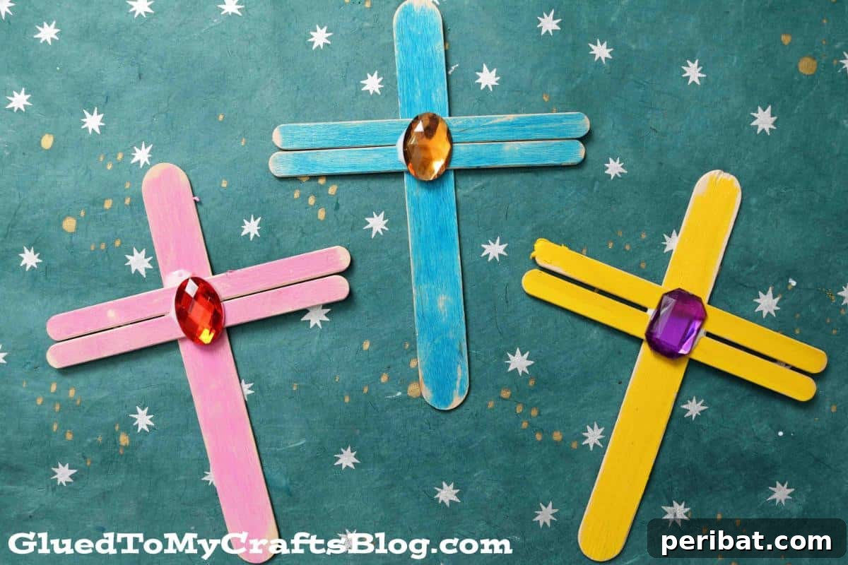 Popsicle stick crosses decorated with glitter and embellishments.