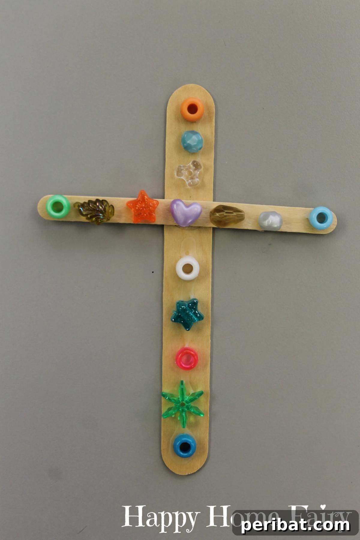 A colorful cross made from craft sticks and various embellishments.