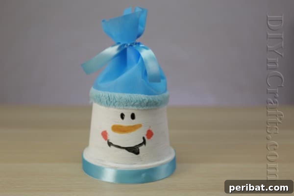 40 Creative Flower Pot Projects 13 A charming snowman crafted from stacked flower pots, with a video tutorial for easy assembly.