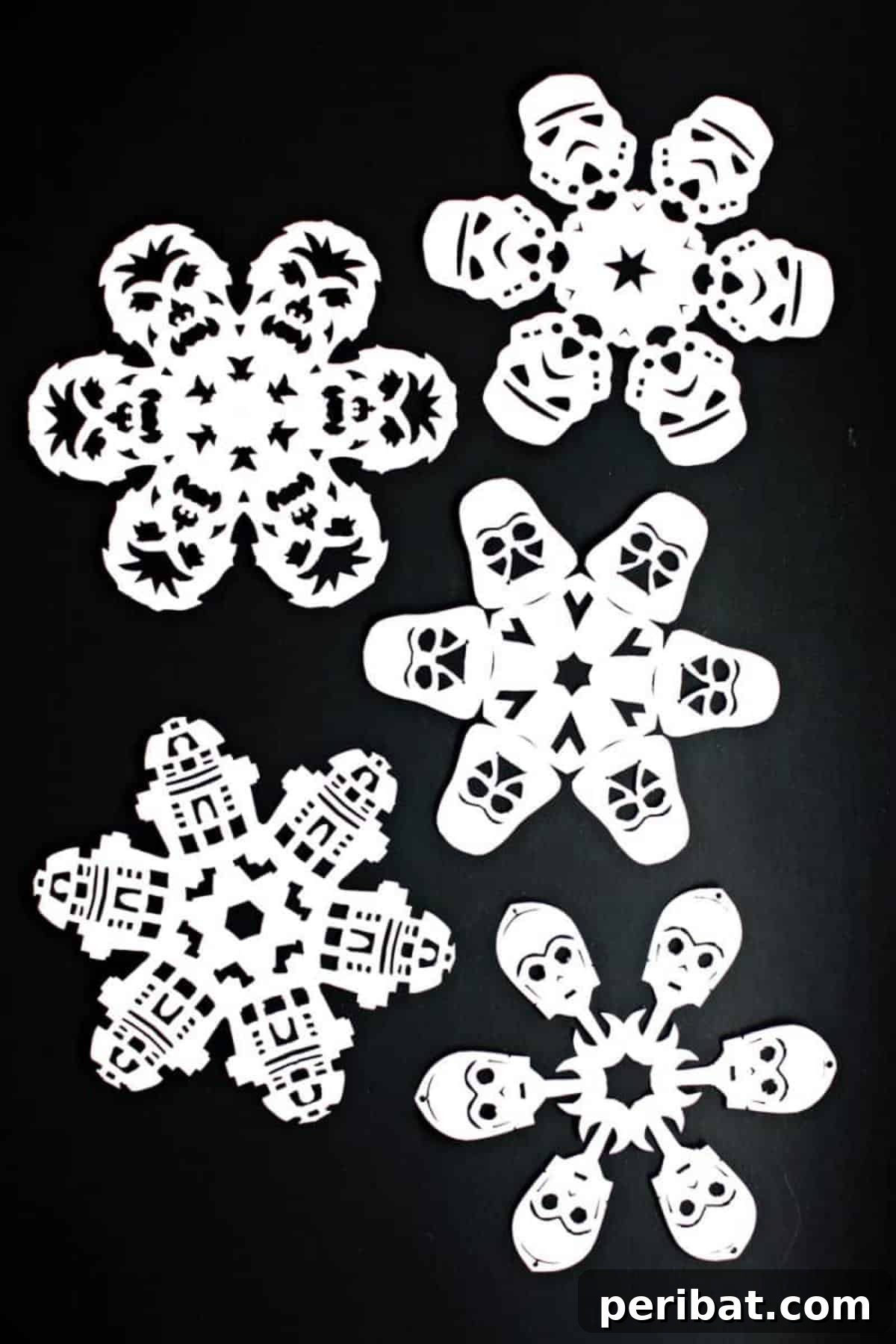 Intricately cut paper snowflakes featuring Star Wars characters like Darth Vader and Stormtroopers.