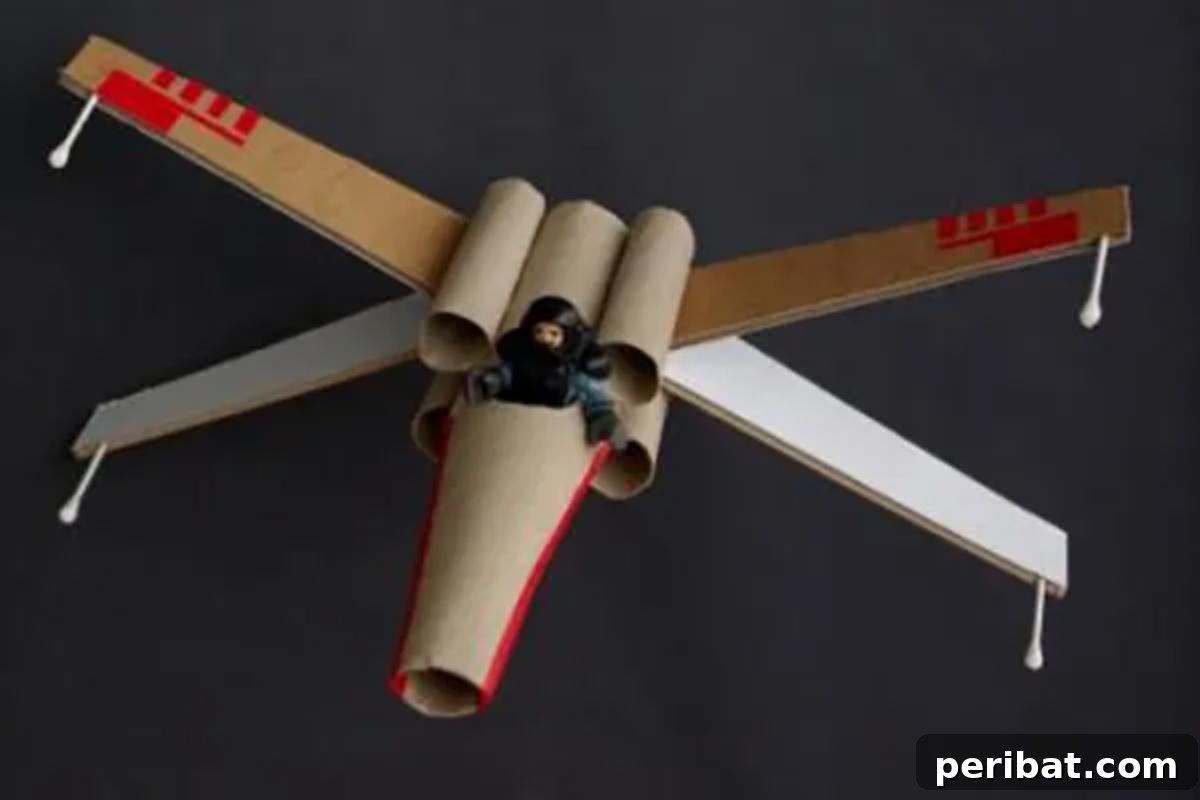Crafting an X-Wing fighter from toilet paper rolls, showing the finished model with intricate details.