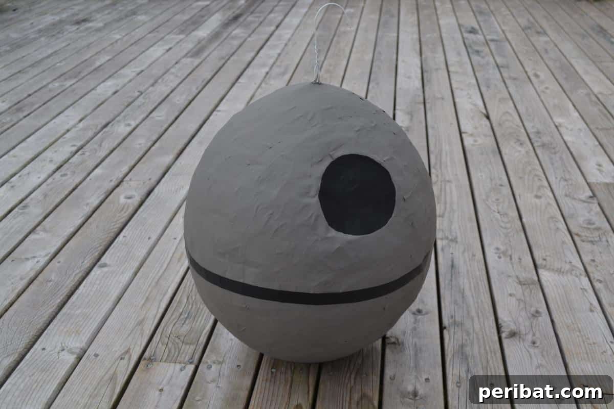 A homemade Death Star piñata hanging, ready for a Star Wars themed party.