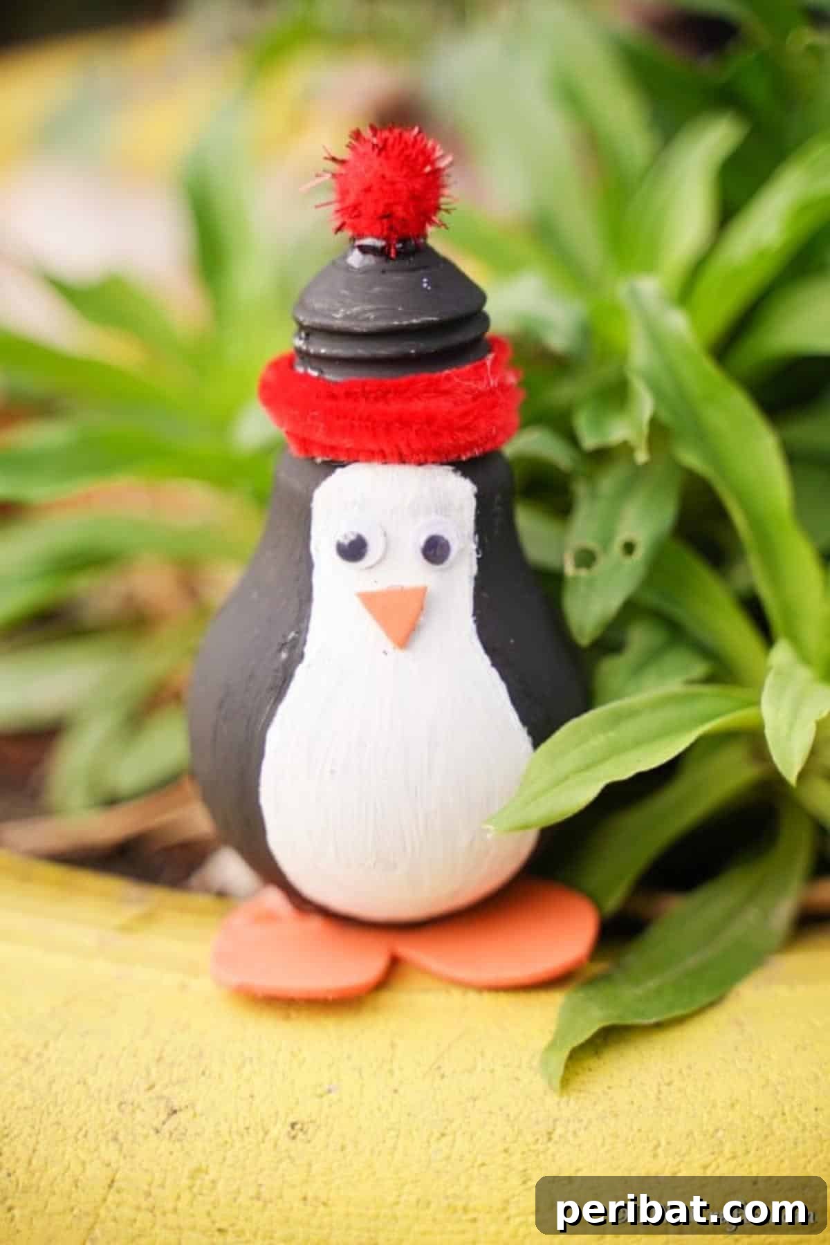 Waddle into Fun: 40 Penguin Craft Projects 7 Painted Christmas Light Bulb Penguin Decoration, transforming old bulbs into festive ornaments.