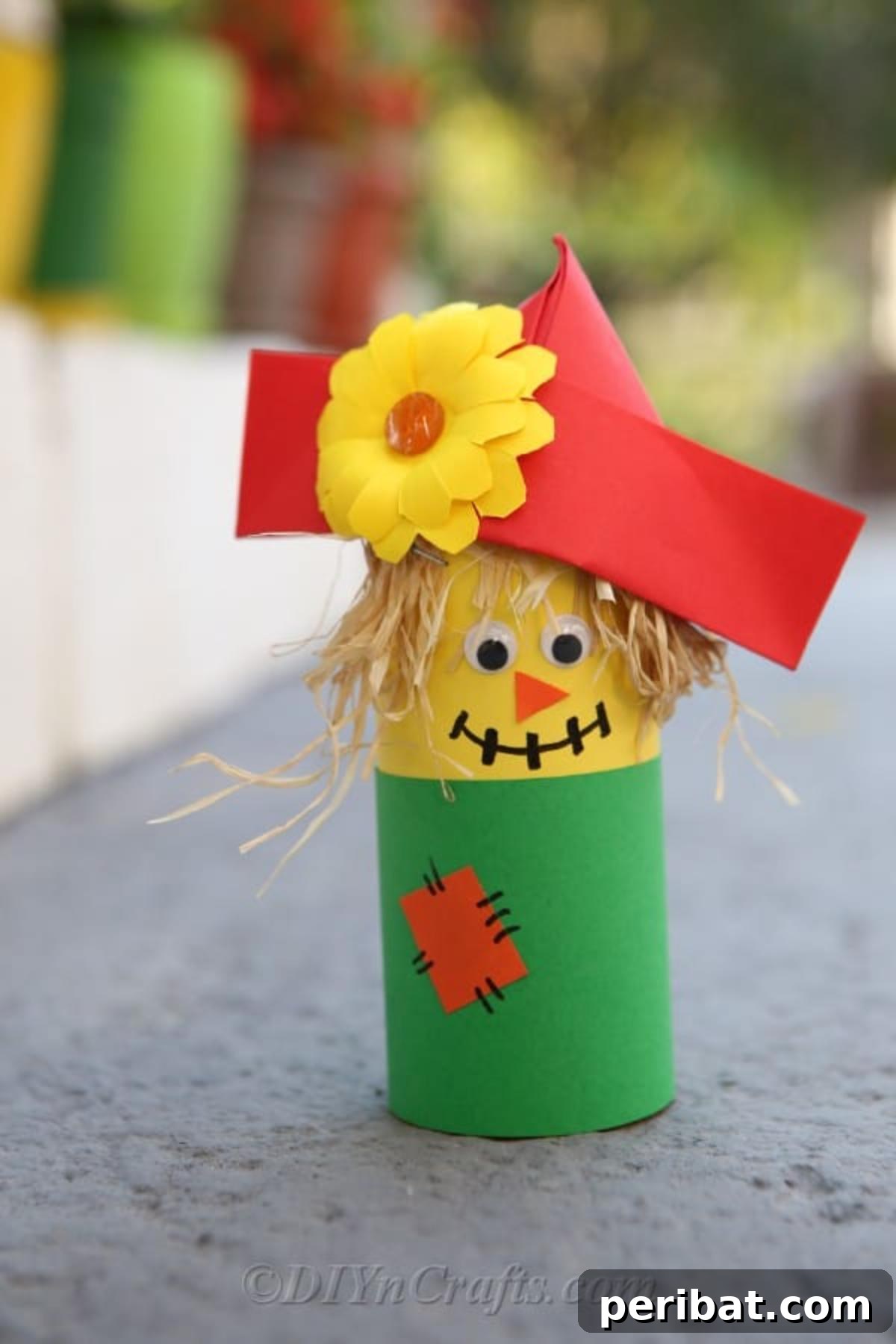 40 Colorful Construction Paper Creations 4 A simple and colorful DIY paper scarecrow craft, made with construction paper cutouts, featuring a friendly face and straw-like hair, ideal for autumn decoration.