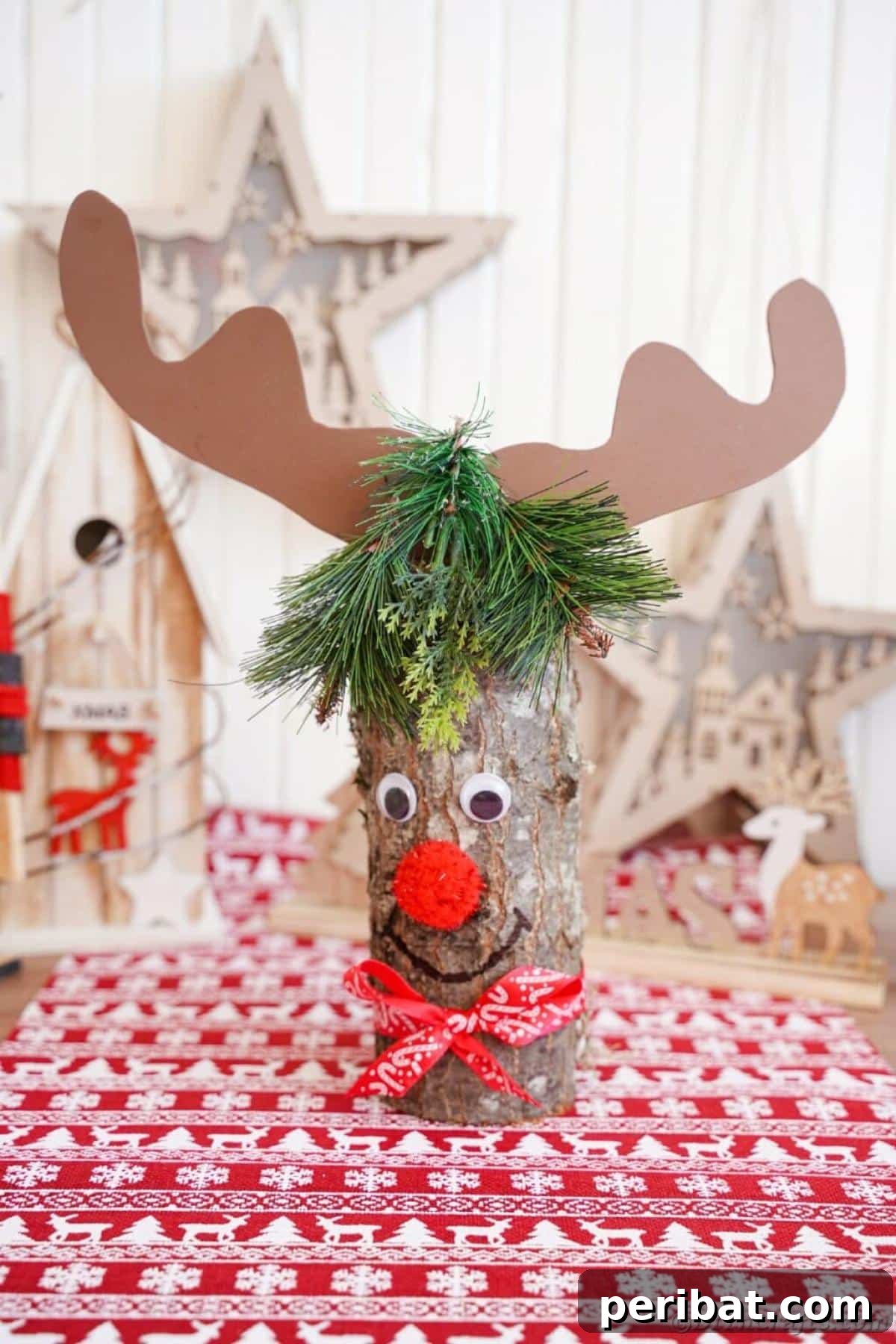 40 Colorful Construction Paper Creations 32 A charming rustic upcycled wood log reindeer Christmas decoration, featuring natural wood for the body and branches for antlers, adorned with a simple red ribbon.