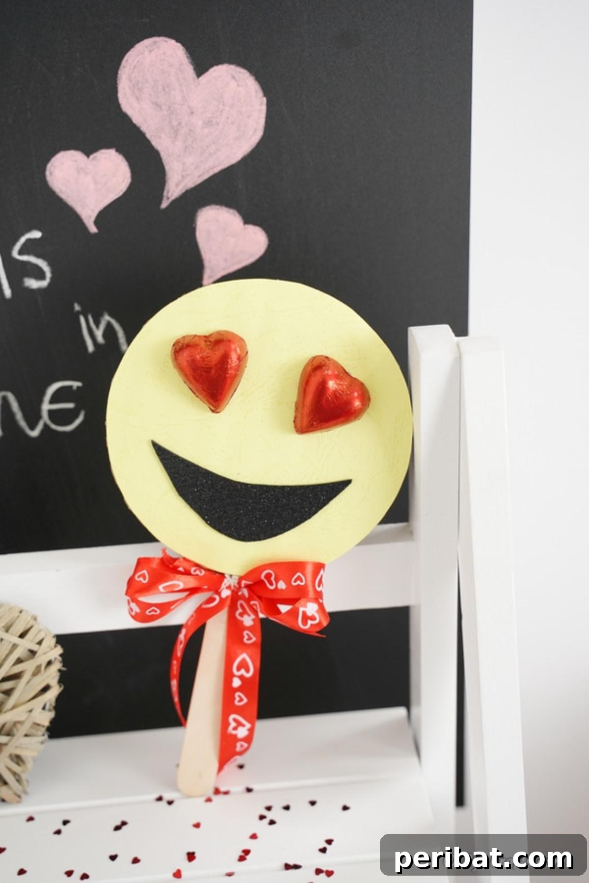 40 Colorful Construction Paper Creations 37 A sweet Valentine's smiley face heart eye emoji decoration, crafted from yellow construction paper with large red heart eyes and a cheerful smile.