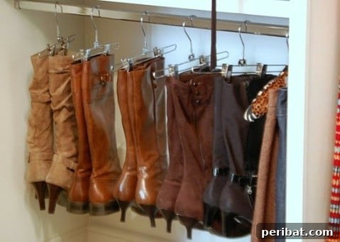 Tall boots neatly hung with pant hangers in a closet