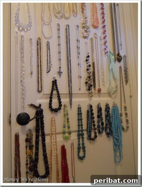 Necklaces and bracelets organized with Command hooks inside a closet door