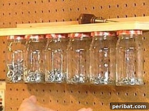 Mason jars attached to the underside of a shelf for garage small parts storage