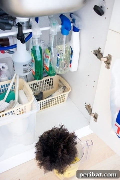 Tension rod installed under a kitchen sink to hang spray bottles