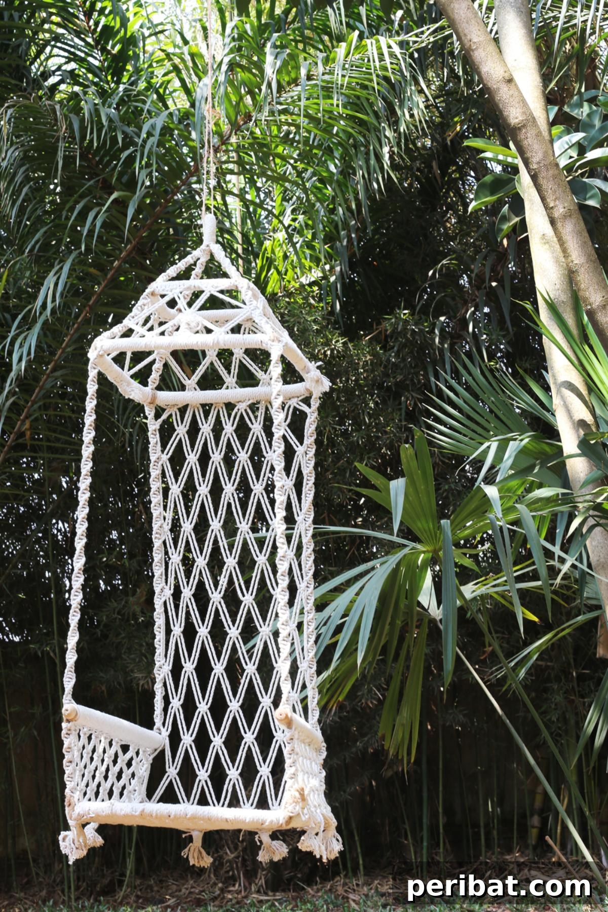 A stunning macramé garden swing, intricately crafted and adorned, bringing an exotic and unique bohemian vibe to an outdoor setting.