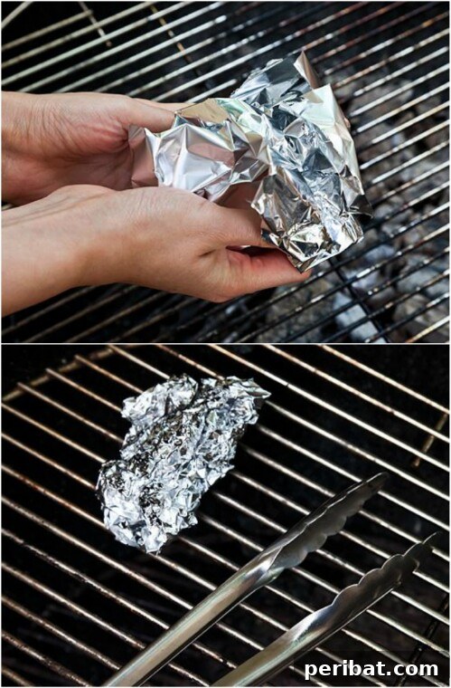 Grilling Game Changers Smart Hacks for Your Best BBQ Ever 7 Aluminum foil ball held by tongs to clean a grill grate