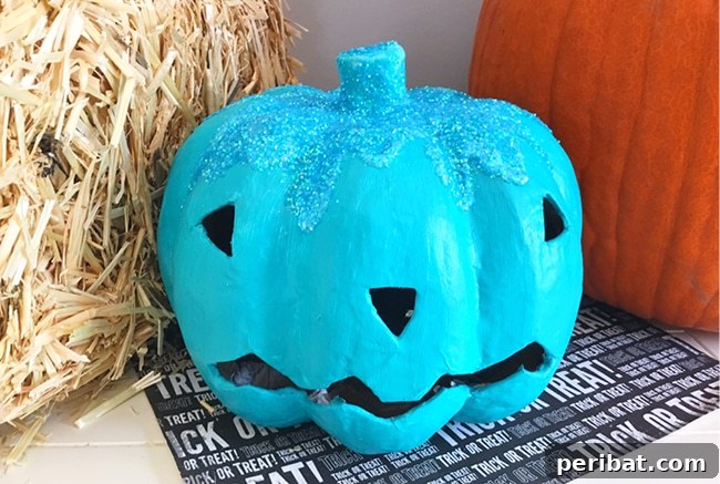 Teal pumpkin by hay bale, symbolizing non-food treats for allergy awareness