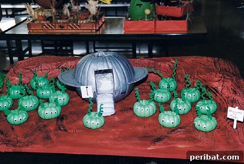 Large pumpkin as a spaceship, small gourds as space aliens for a creative Halloween display