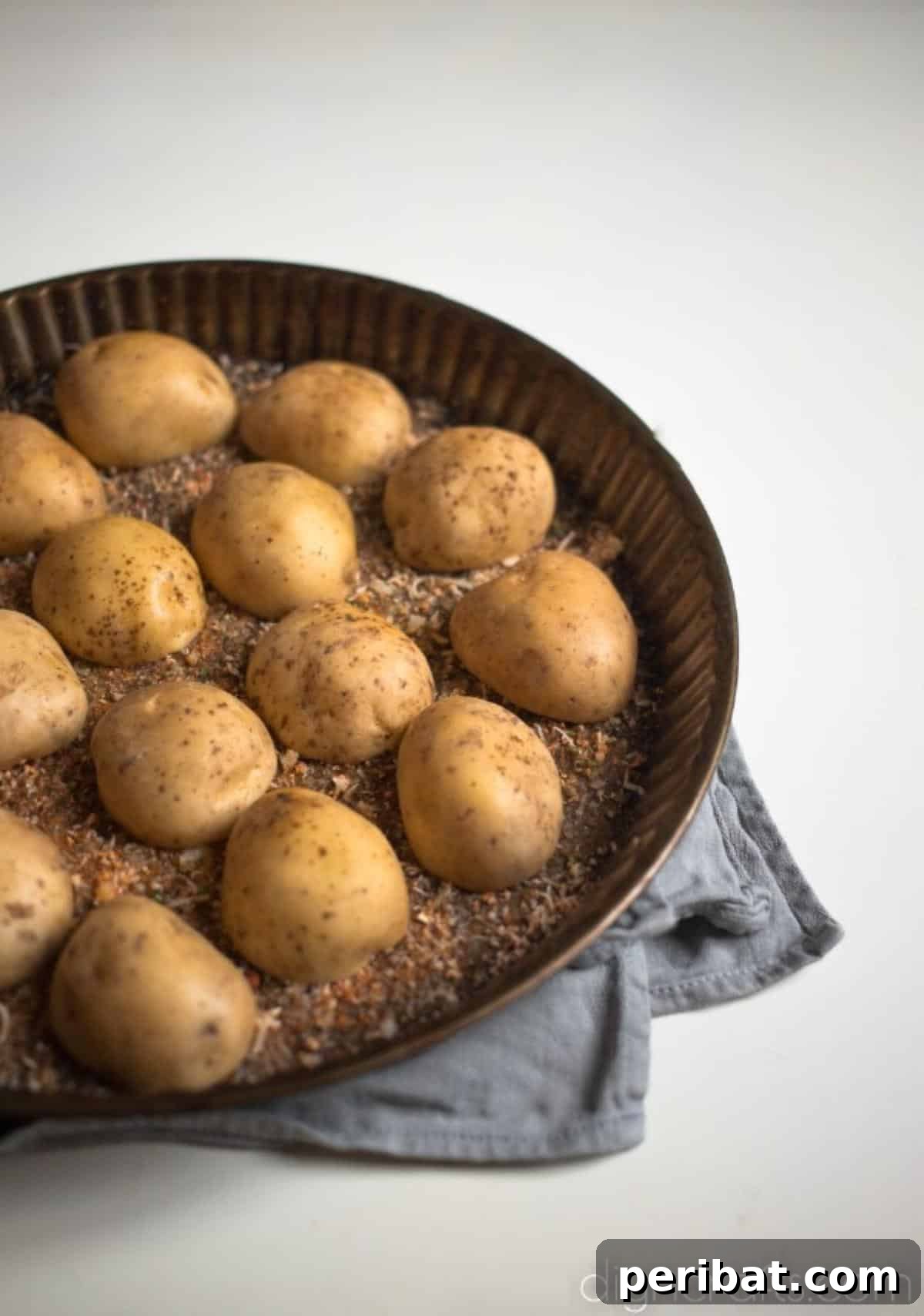 Seasoning the potato halves.