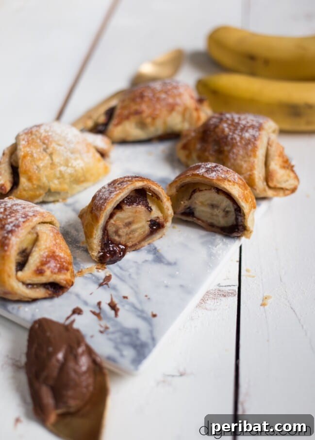 Finished Banana and Nutella Stuffed Puff Pastry Rolls, golden and flaky on a plate.