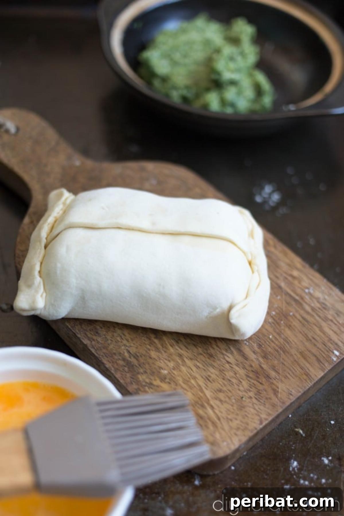 Elevate Your Brunch: Light Salmon Wellington Perfection 6 An uncooked Salmon Wellington, neatly wrapped in puff pastry with crosshatch slits, awaiting baking.
