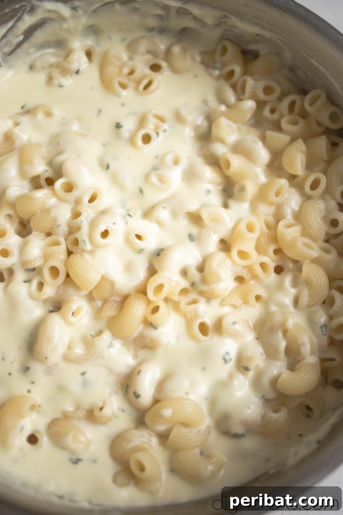 The Ultimate Decadent Mac and Cheese 5 Cooked macaroni pasta being mixed thoroughly with the creamy homemade cheese sauce.
