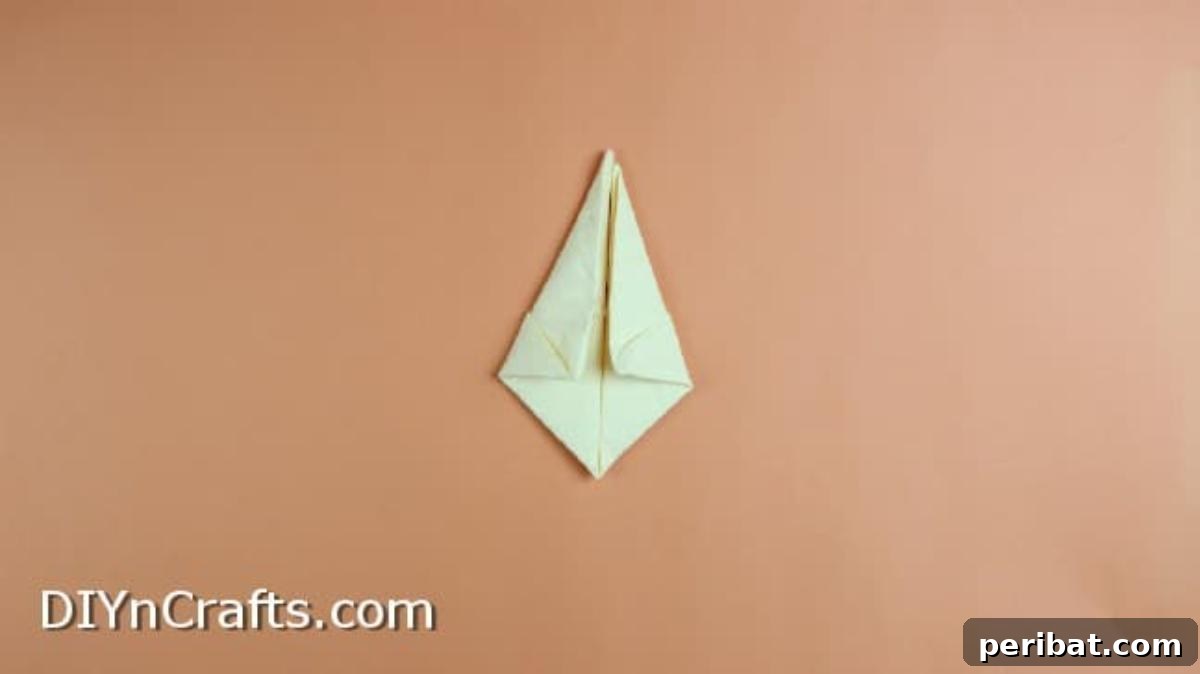 Effortless Adorable Easter Bunny Napkin Place Settings 7 Folding the napkin sides down to form a kite shape for the bunny's face.