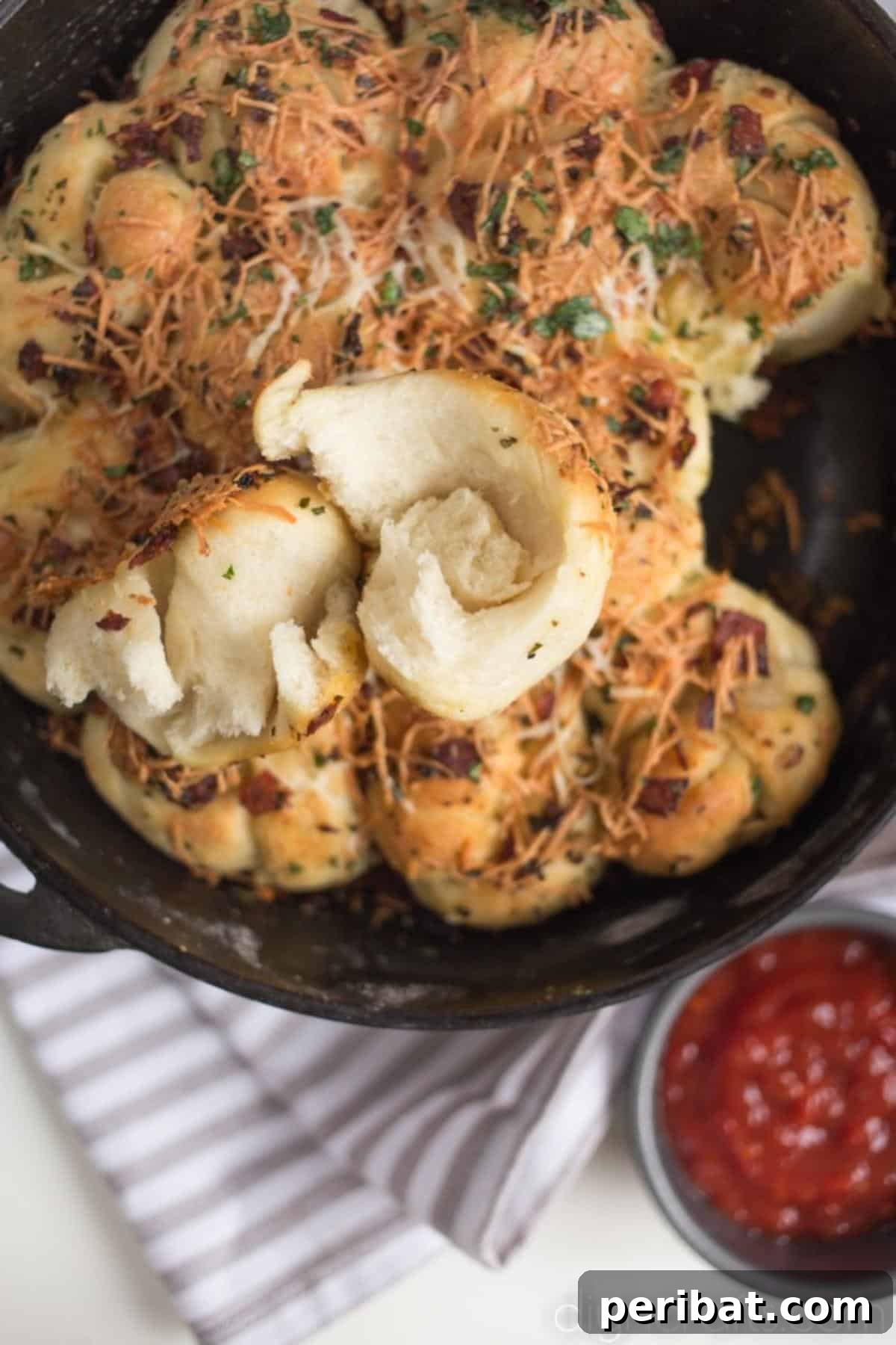 Pull-Apart Pepperoni Garlic Knots: Pure Appetizer Perfection 8 A close-up of a single golden-brown pepperoni garlic knot, showing the melted cheese and visible pepperoni pieces, with a focus on its delicious texture.