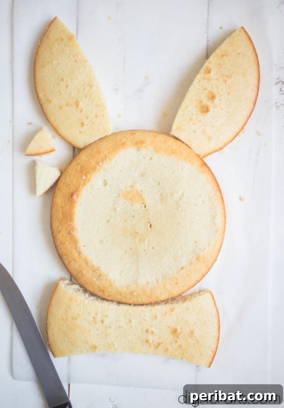 Hem Şirin Hem Lezzetli Paskalya Tavşanı Pastası Tarifi 6 The process of shaping the Easter Bunny cake, showing how two round cakes are cut and arranged to form the bunny's face and ears. This clever cutting technique eliminates the need for special pans.