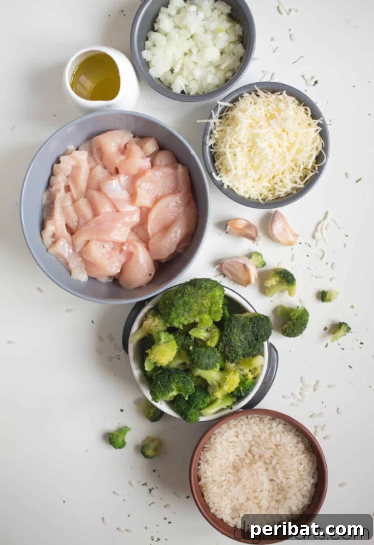 One-Pan Cheesy Chicken and Broccoli Rice Perfection 3 Fresh ingredients laid out for Cheesy Chicken, Broccoli, and Rice including chicken, rice, broccoli, onion, and cheese