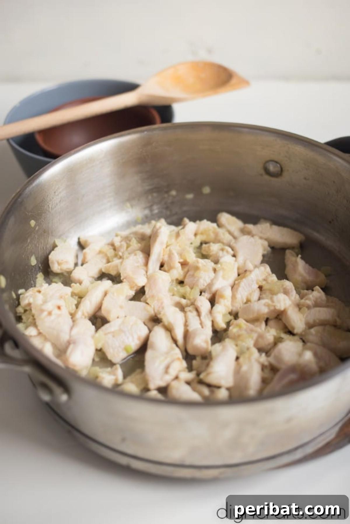 One-Pan Cheesy Chicken and Broccoli Rice Perfection 4 Chicken pieces cooking in olive oil with onions in a large pan