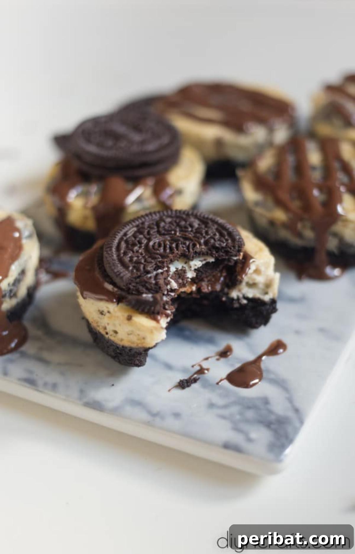 Delicious Oreo and chocolate bites - A close-up shot of multiple Oreo cheesecake bites arranged on a plate, featuring their chocolate drizzle and cookie crust, ready to be enjoyed.