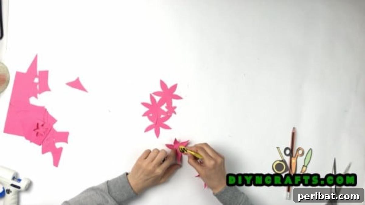 Gluing the folded paper flower petals to create a layered effect.