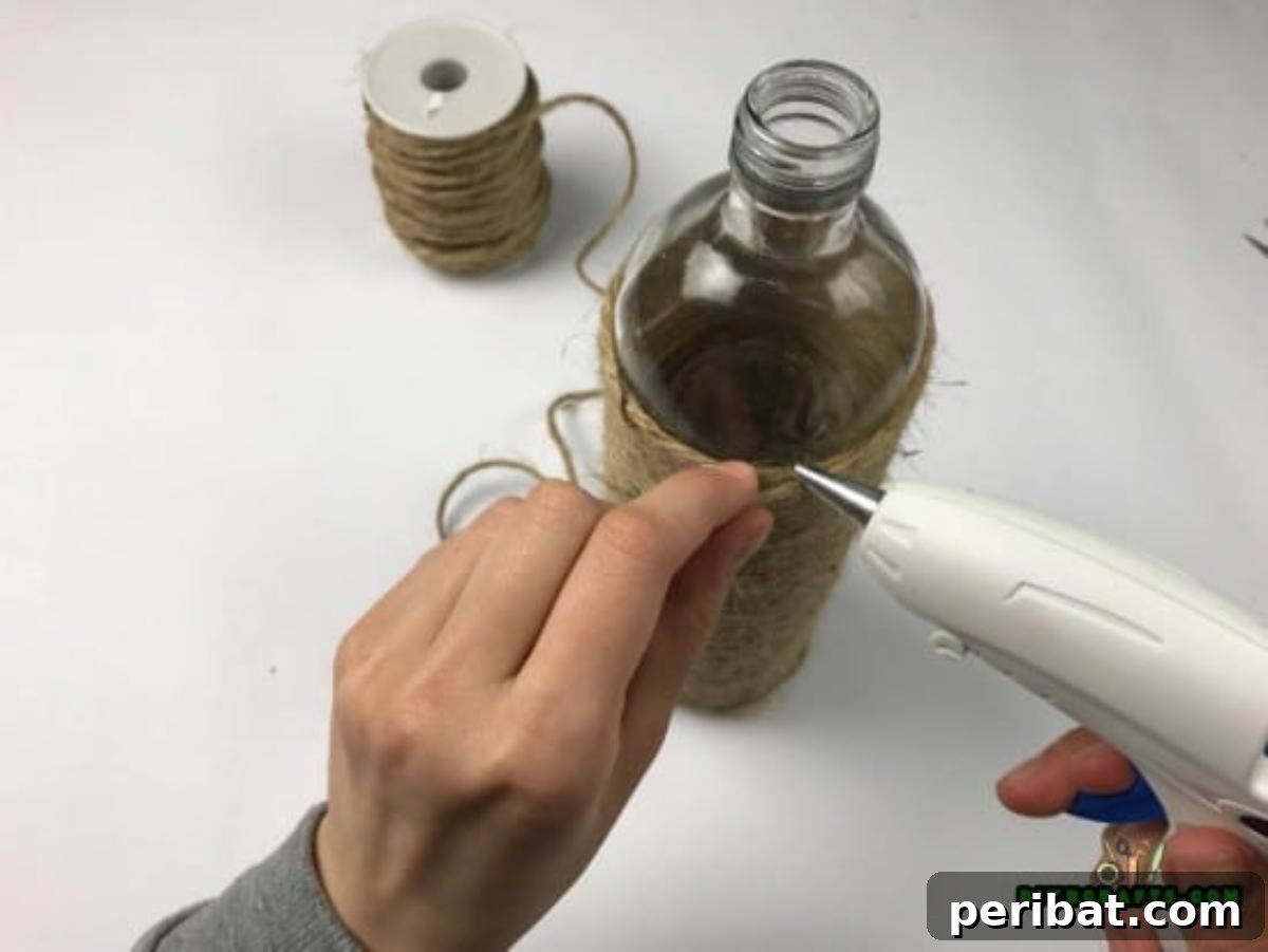 Craft Beautiful Vases from Repurposed Wine Bottles 4 Gluing the twine around the bottle for a rustic look.