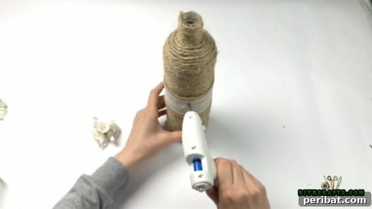Craft Beautiful Vases from Repurposed Wine Bottles 5 Decorating the twine-wrapped bottle with additional elements like burlap and flowers.