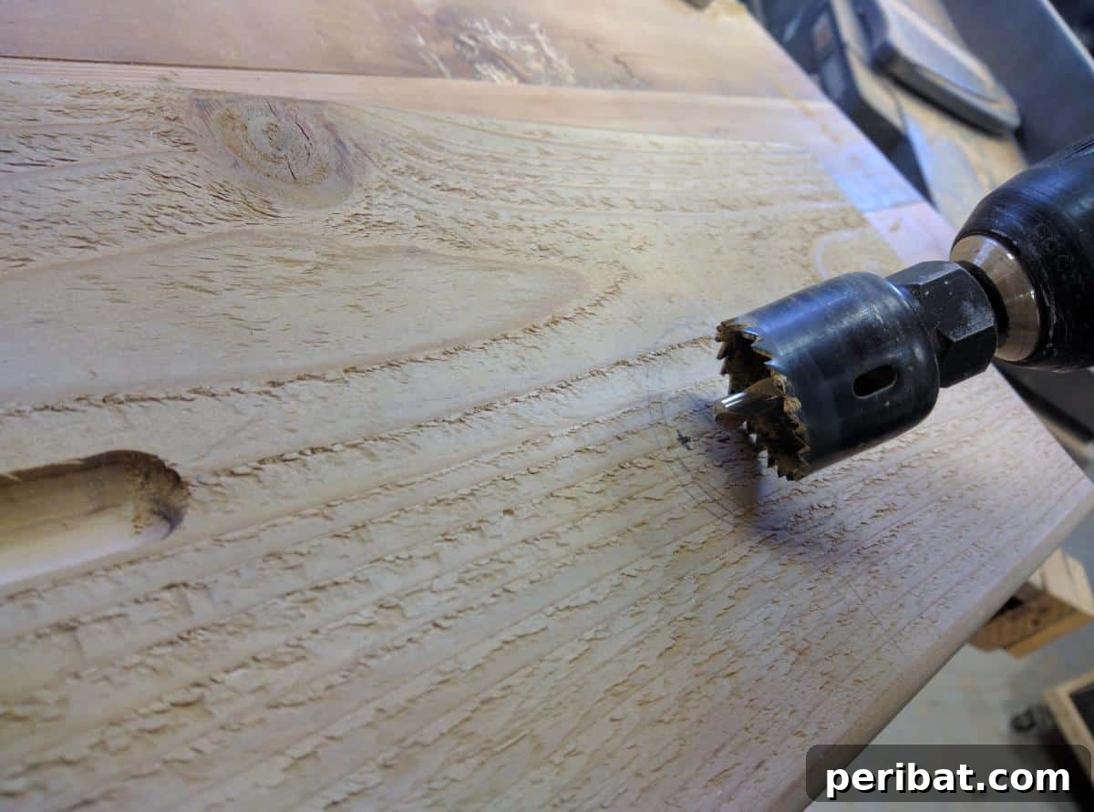 Drilling circular holes into the bath tray using a hole saw for holding cups or mugs.
