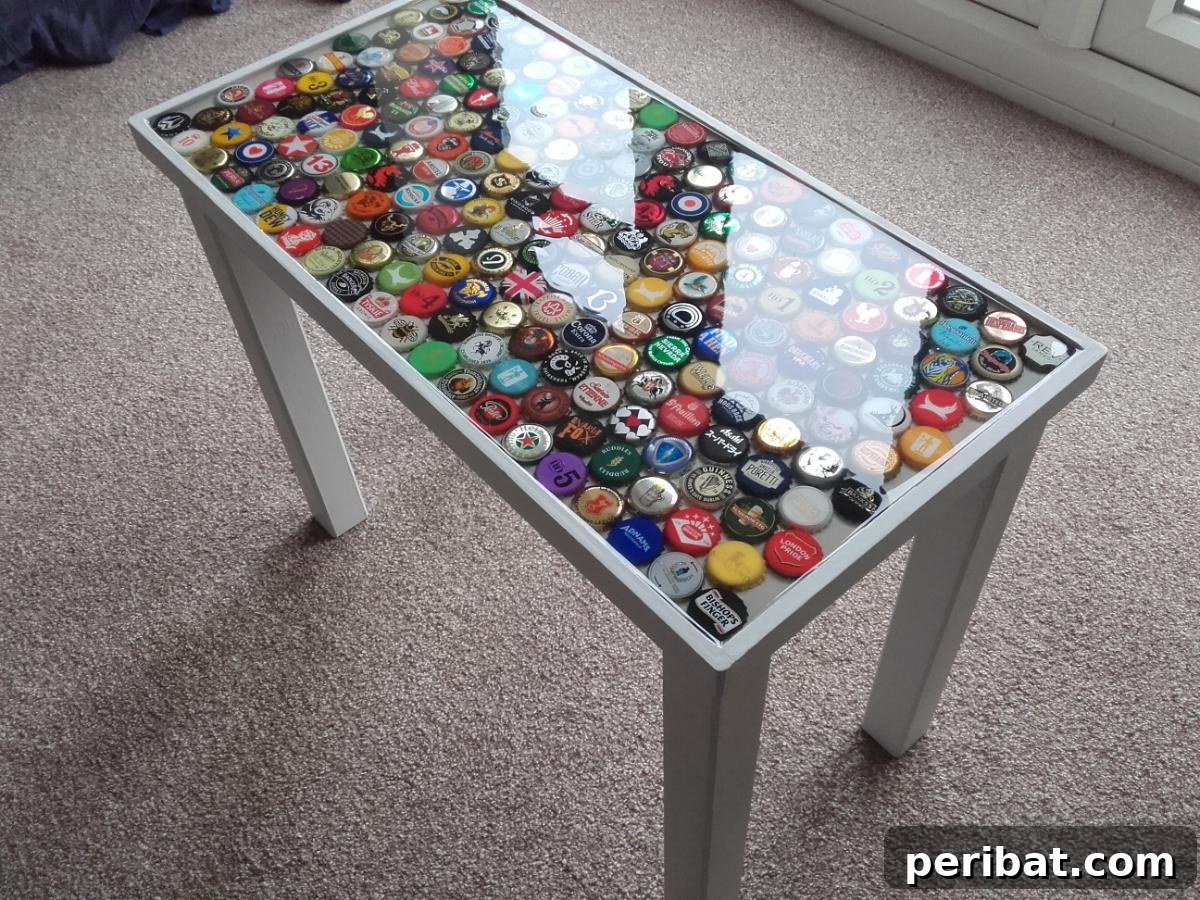 Man Cave Upgrade: Build a Vibrant Bottle Cap Table 8 Bottle cap table with the first layer of epoxy resin poured, showcasing the glossy transformation.