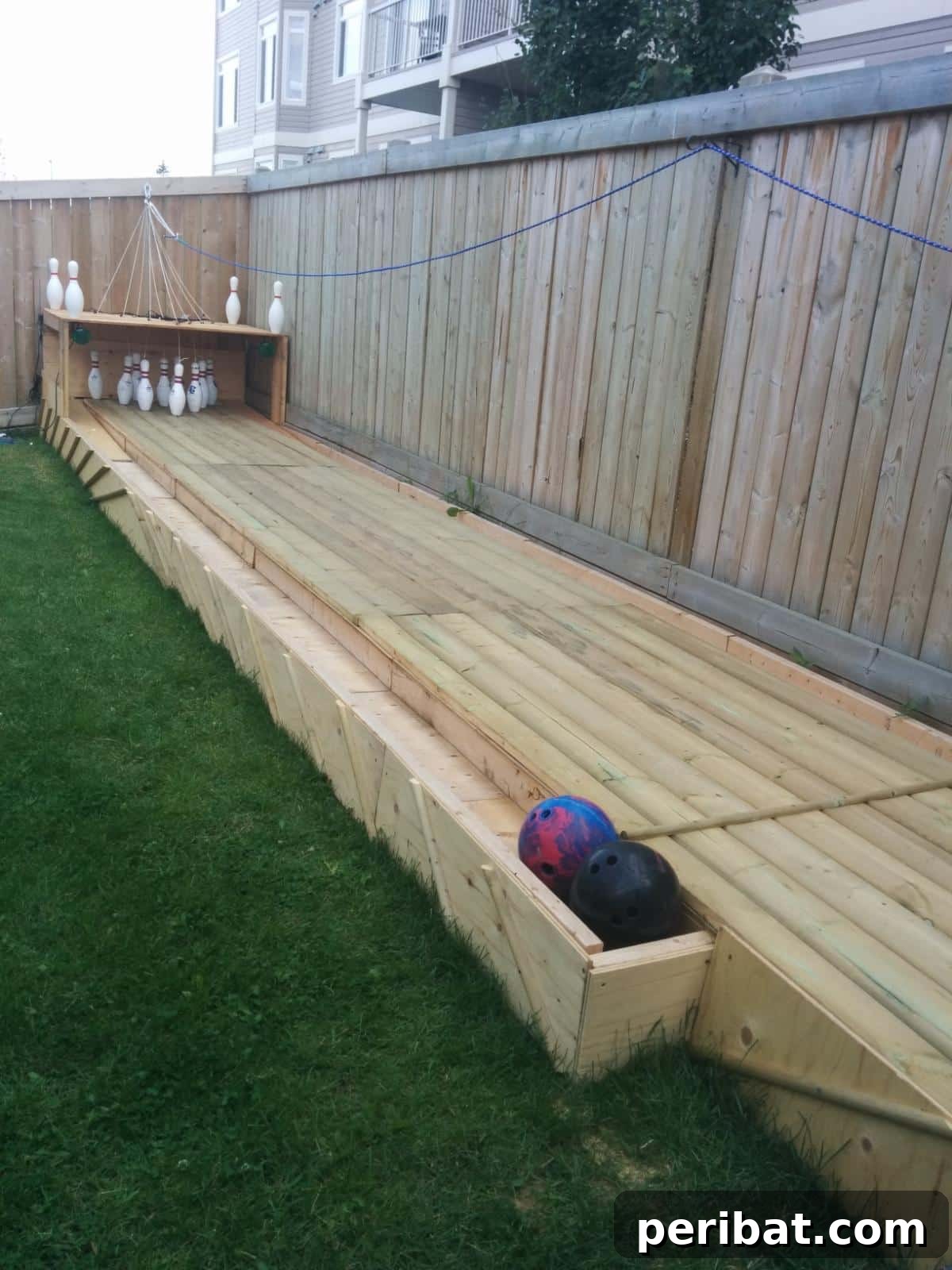 Build Your Own Backyard Bowling Alley for Summer Fun 3 A beautifully constructed backyard bowling alley, complete with lane, pins, and return system.