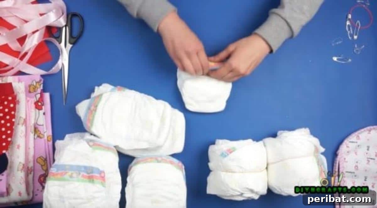 Roll 4 diapers into one another to create a wheel. Do this 6 times so you have 6 wheels.