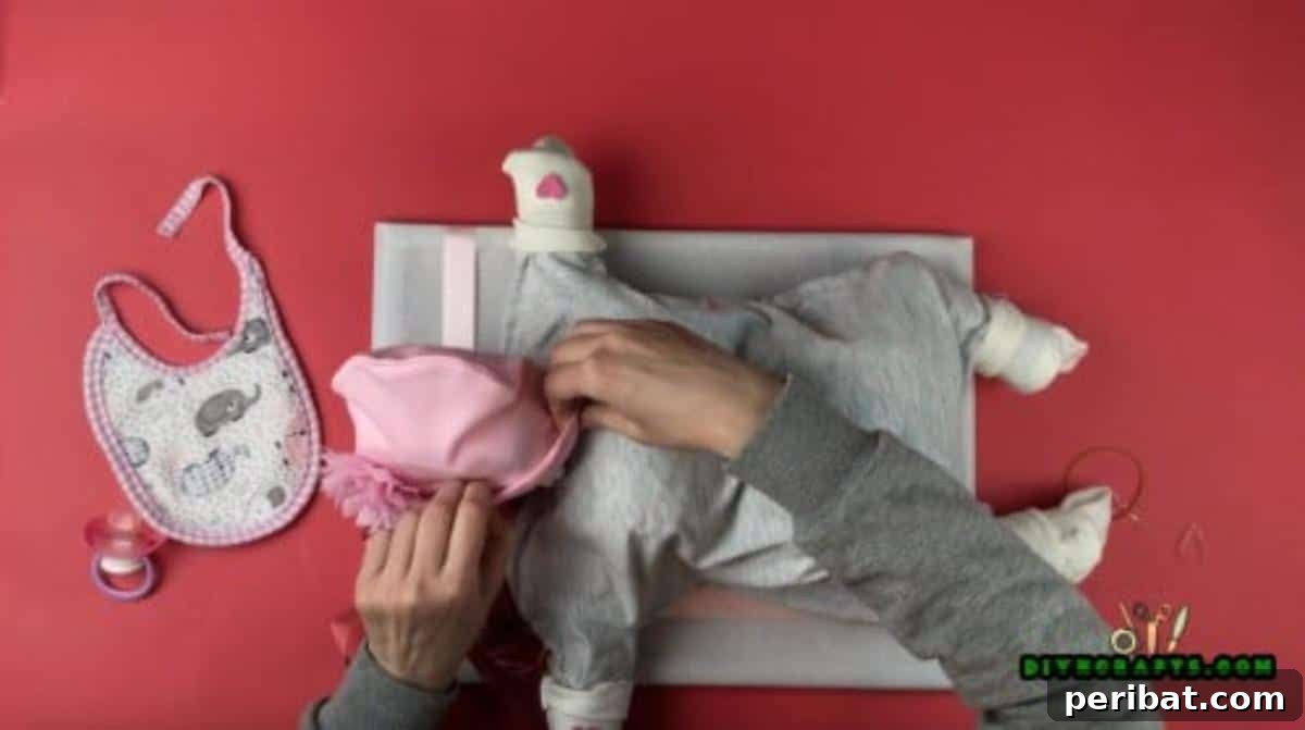 Crafting an Adorable Diaper Baby Gift 5 A close-up view of the diaper baby's head, showcasing the baby hat neatly placed on top and pulled down to just above the pacifier, creating a sweet and cozy look.
