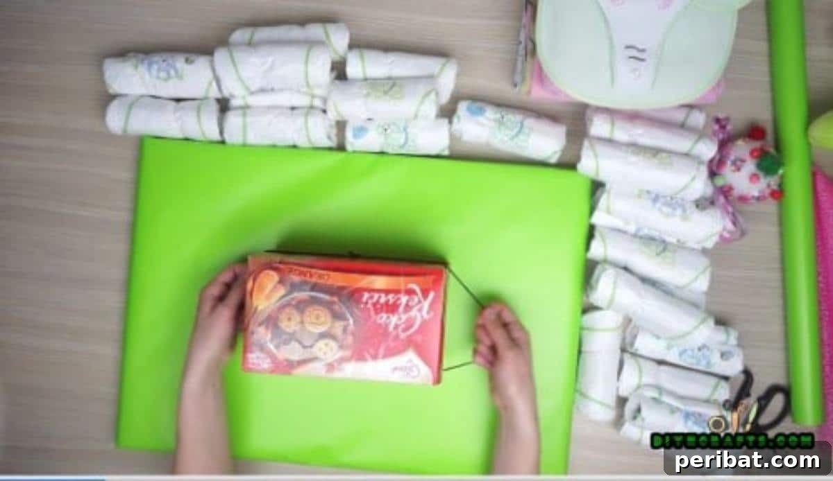 Wrap a large rubber band around the chocolate box base for the diaper cake boat.