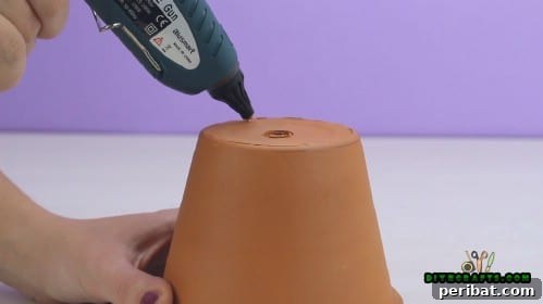 Upcycle Pots and Trays into a Beautiful Jewelry Stand 4 Hot glue applied to the inverted bottom of the large clay pot, ready for the tray.