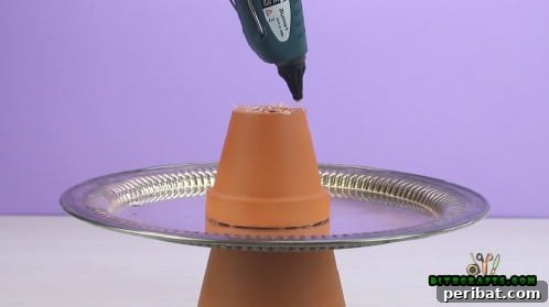 Upcycle Pots and Trays into a Beautiful Jewelry Stand 7 Hot glue applied to the top of the inverted smaller pot, ready for the final plate.