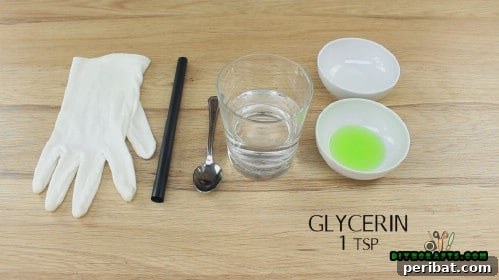 All ingredients for bouncing bubbles laid out on a table: a straw, a glass of distilled water, dish soap, and glycerin.