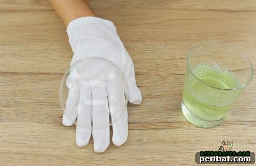 A child's gloved hand gently bouncing a large bubble, demonstrating the non-popping effect.