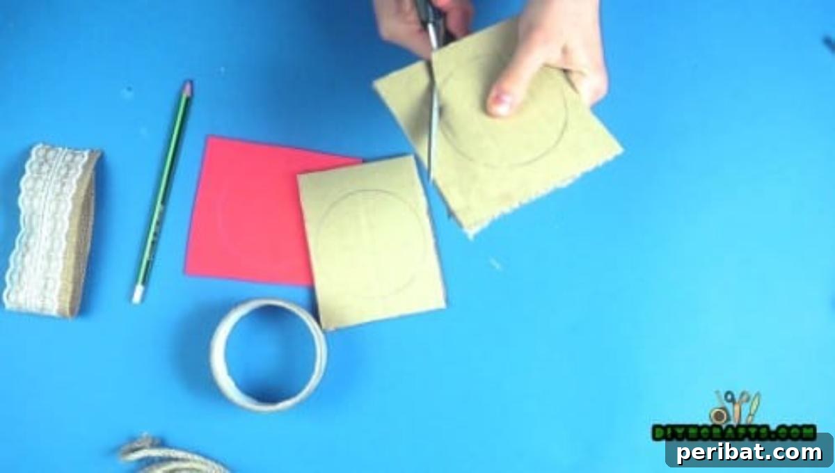 A hand cutting a traced cardboard circle with scissors.