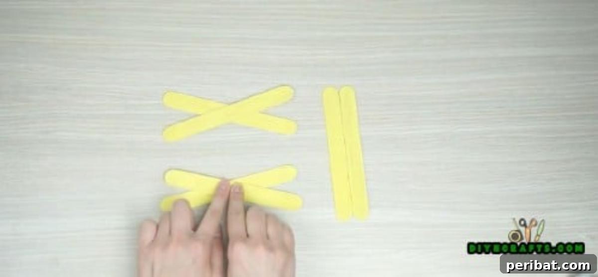Popsicle Stick Perfection: Easy DIY Napkin Holders 7 The second X-shape, identical to the first, secured with hot glue.