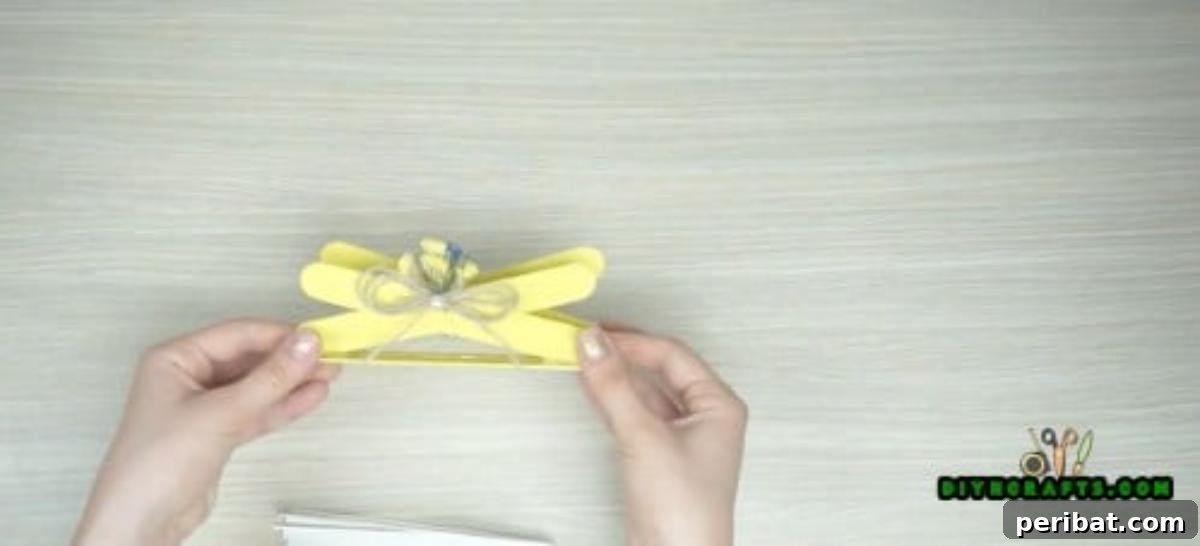 Popsicle Stick Perfection: Easy DIY Napkin Holders 9 Add whatever pretty embellishments you want to personalize your napkin holder.