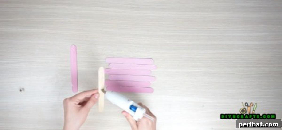 Transform Popsicle Sticks into Adorable Coasters 3 Assembling the base of the DIY square coaster with hot glue and popsicle sticks.